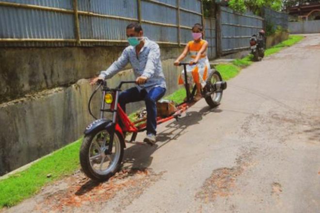 Indian rider extends motorcycle, follows social distancing image