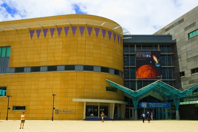 Museum visitor climbs on motorcycle exhibit image